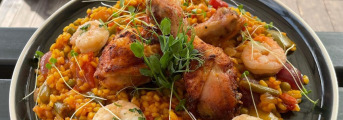 Španielska paella s chorizom, krevetami a pečenými kuracími stehienkami